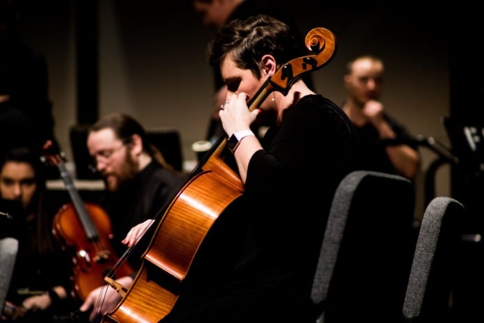 Playing a cello in an orchestra